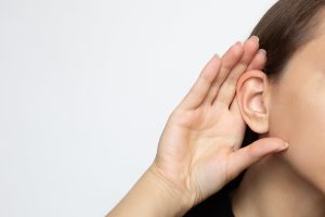 Lady holding her ear.